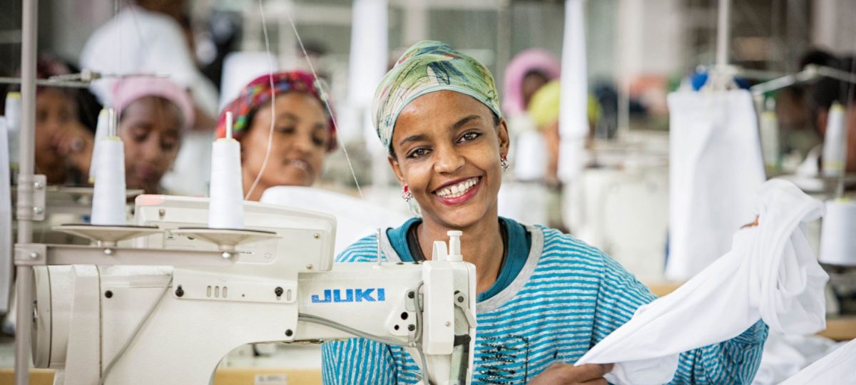 vrouw aan het werk achter de naaimachine in textielfabriek