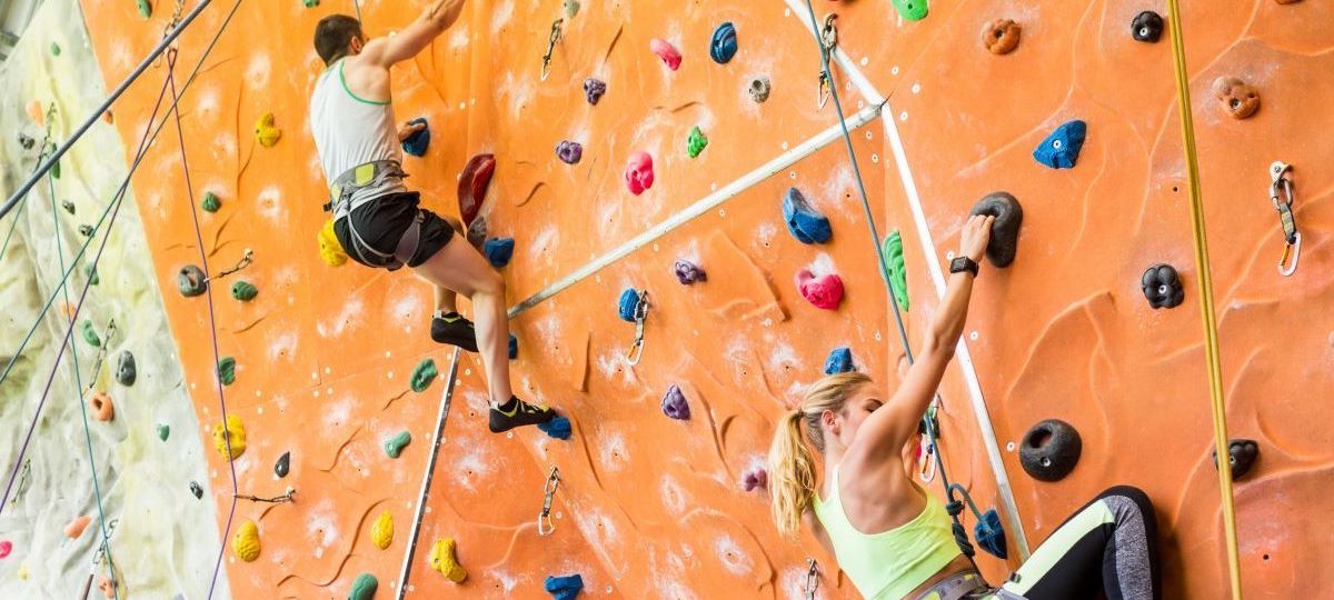 Een man en een vrouw op een indoor klimwand.