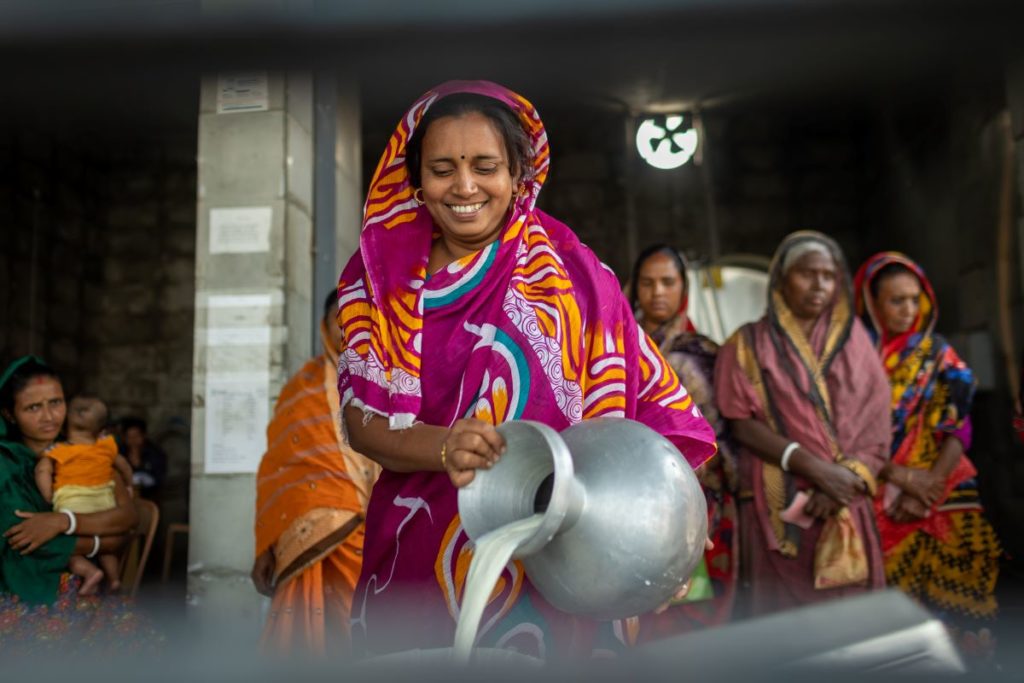 Vrouw met melkkan in Bangladesh